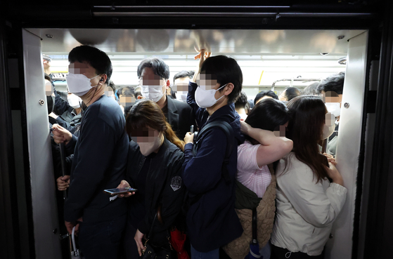 Passengers squeeze into a subway car at Gochon Station on Gimpo Gold Line on April 18. [YONHAP]