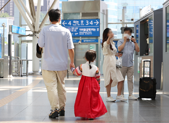 A child dresssed in hanbok walks along a platform at Seoul Station with her parent on the first day of the Chuseok holiday on Sept. 9, 2022. [YONHAP]