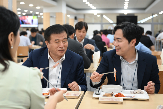 President Yoon Suk Yeol's senior secretary for political affairs Lee Jin-bok, left, is seen having a meal featuring Korean seafood at the Yongsan Presidential Office cafeteria on the Monday. In an effort to address concerns related to the release of treated radioactive water from Japan's Fukushima Daiichi nuclear plant and promote seafood consumption, the Presidential Office introduced domestic seafood to the cafeteria menu for a week starting from Monday. [PRESIDENTIAL OFFICE]
