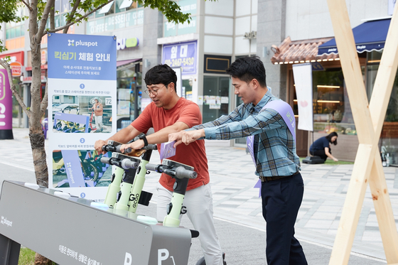 An employee at CurrentDot, an internal startup at LG Electronics, demonstrates how to use Pluspot, a parking platform app for electric scooters, at the app's launching ceremony at Sejong on Tuesday. [LG ELECTRONICS]
