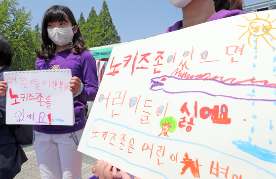 Children hold sketchbooks with anti-"No Kids" zone slogans during a press conference held in front of the National Assembly on May 4, 2022. [NEWS1]