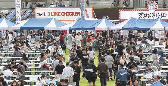 Visitors to the 2023 Daegu Chimac Festival eat chicken and drink beer at the event held in Dalseo District, Daegu, on Wednesday. [YONHAP]