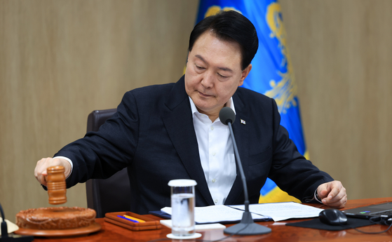 President Yoon Suk Yeol bangs the gavel as he presides over a Cabinet meeting to discuss next year’s budget at the Yongsan presidential office in central Seoul Tuesday. [PRESIDENTIAL OFFICE]