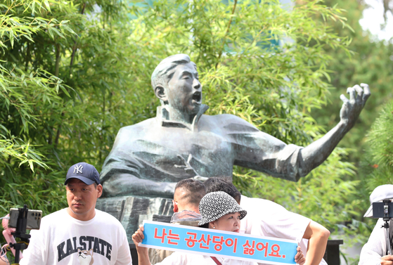Members of conservative groups hold a protest in front of a bust of Jeong Yul-sung, a naturalized Chinese composer revered in China and North Korea for composing military anthems, located in Gwangju on Monda. A protestor holds up a sign that reads ″I dont' like the communist party.″ [NEWS1] 