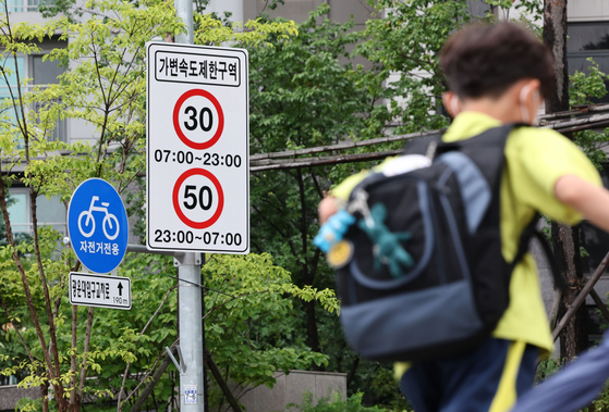 A speed limit sign with new speed caps stands in front of Gwangun Elementary School in Seongbuk District, northern Seoul, where the change has been in trial since July 2022. [YONHAP]