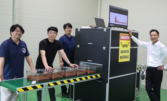 Members of the 3I Solution team pose in front of the neutron composition analyzer. [HYUNDAI STEEL]