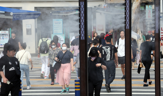 Cooling fog is sprayed on a street in Busan to lower the temperature on Aug. 15. [JOONGAHG PHOTO]