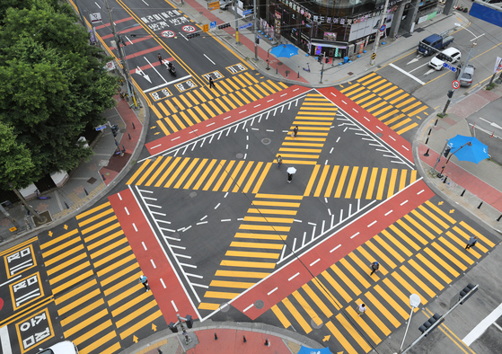 Thicker, more vivid yellow lines are printed at a crosswalk in front of Gugal Elementary School in Yongin, Gyeonggi, on June 7, when a newly reformed traffic regulation aimed at increasing drivers' awareness was implemented. [NEWS1]