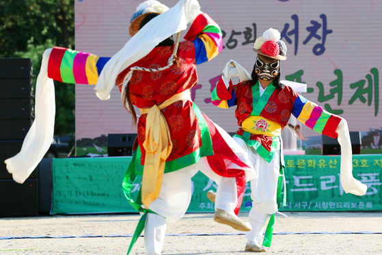 Dancers wearing Korean traditional clothes and masks perform at a ceremony praying for a rich harvest season in Gwangju's Seo District on Thursday. [YONHAP]
