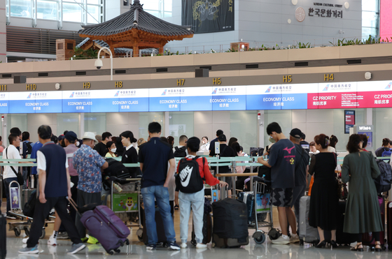 Passengers wait for check-in at Incheon International Airport on Monday. [NEWS1]