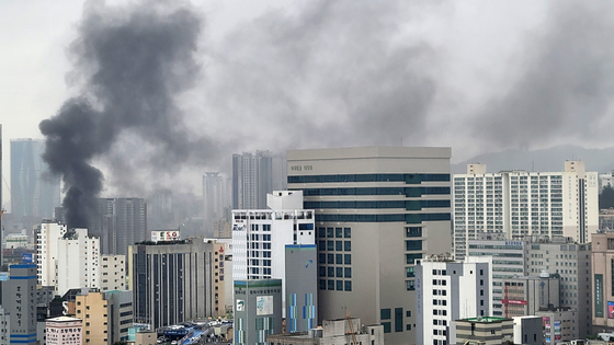Smoke rises above the buildings in Busan as a fire, followed by explosions, broke out at a public bath in Busan on Friday. [YONHAP]