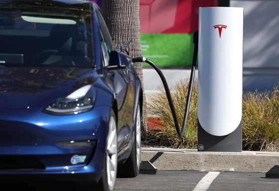 A Tesla car sits at a Tesla Supercharger station on Feb. 15 in Sausalito, California. [AFP/YONHAP]