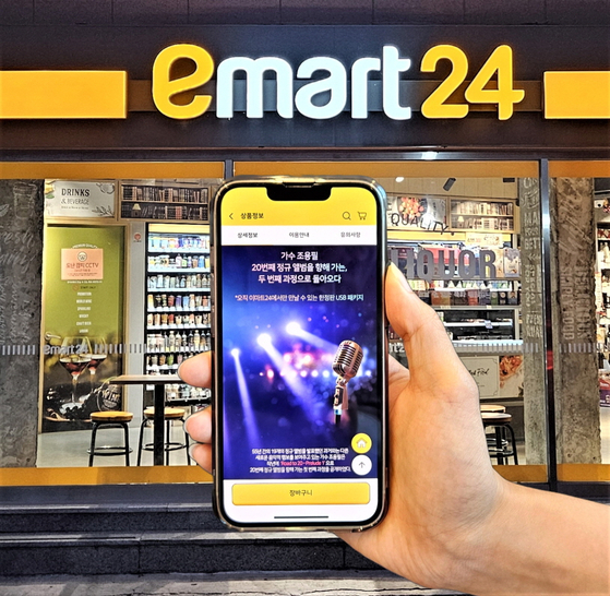 A model showcases Cho Yong-pil's limited edition USB album at an Emart24 store. [EMART24]