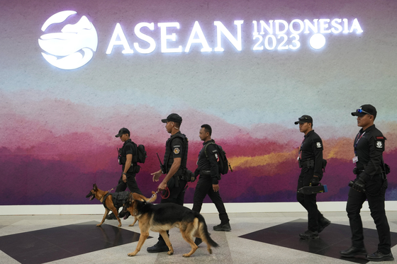 A bomb squad unit leads sniffer dogs as they patrol outside the venue of the upcoming Asean Summit in Jakarta, Indonesia, on Monday. [AP/YONHAP]