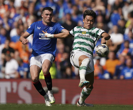 Rangers' John Souttar, left, and Celtic's Oh Hyeon-gyu battle for the ball during a Scottish Premiership match at the Ibrox Stadium in Glasgow on Sunday.  [AP/YONHAP]