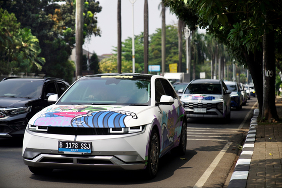 Hyundai Motor's "Art cars" with printings symbolize the city of Busan and a sign saying "Busan is Ready" in Jakarta, Indonesia, where the 43rd Summit of Southeast Asian Nations will be held starting on Tuesday. Hyundai designed the art cars, based on the Ioniq 5, Ioniq 6 and Genesis electric G80, in collaboration with artist JAY FLOW, to promote Busan's bid for hosting the World Expo 2030. A total of 23 art cars will be touring downtown Jakarta during the summit period. [HYUNDAI MOTOR]