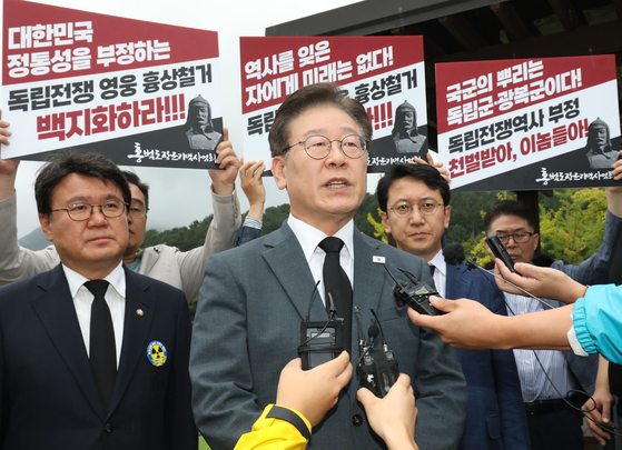 Democratic Party leader Lee Jae-myung speaks with the press during a rally to oppose the government decision to remove the bust of Hong Beom-do and other independence fighters with ties to communism from the Defense Ministry headquarters and a military academy, at a cemetery in Daejeon where Hong's remains lie on Aug. 29. [YONHAP]