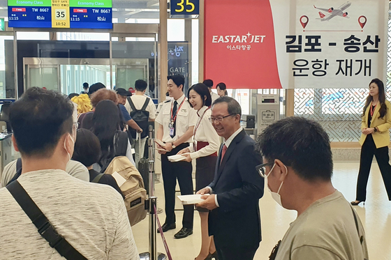 Eastar Jet President and CEO Cho Joong-seok and employees hand out souvenirs to the passengers on their inaugural international flight to Taipei from Seoul on Saturday. [EASTAR JET]