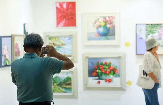 People visit the ″Art in LotteMart″ art exhibition held at a Lotte Mart in Songpa District, southern Seoul, on Monday. [YONHAP]