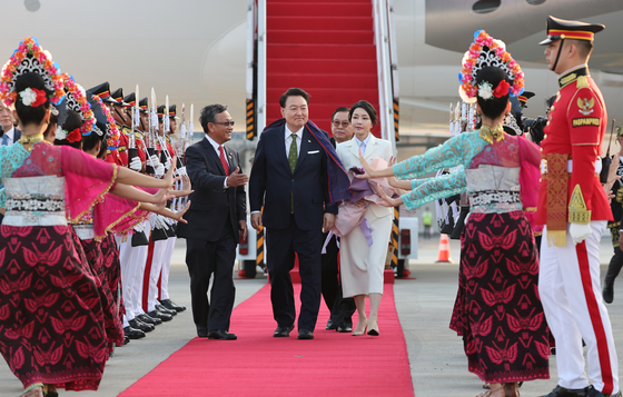 President Yoon Suk Yeol, center, and first lady Kim Keon Hee, right, are greeted by Indonesian officials and a group of dancers welcoming the Korean delegation arriving at Soekarno-Hatta International Airport in Jakarta, Indonesia, Tuesday. [JOINT PRESS CORPS]