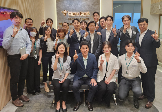 Hana Financial Group Chairman Ham Young-joo, second from left in the front row, poses for a photo with employees of Hana Bank's Hong Kong branch on Tuesday. [HANA FINANCIAL GROUP]