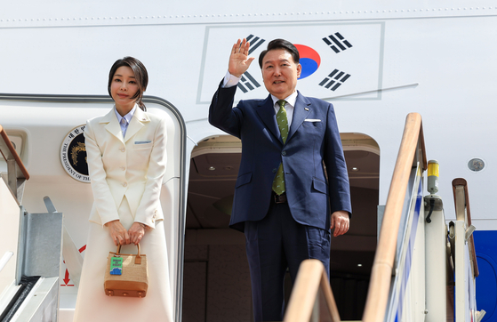 President Yoon Suk Yeol, right, waves alongside first lady Kim Keon Hee as they depart on the presidential jet from the Seoul Air Base in Gyeonggi, on Tuesday beginning a weeklong visit to Indonesia and India for Asean and G20 events. [JOINT PRESS CORPS]