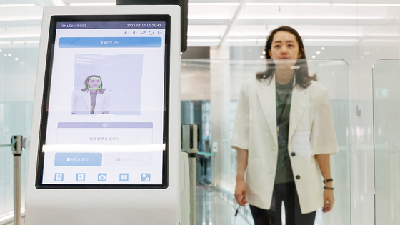 An Incheon International Airport employee demonstrates the Smart Pass service on July 10. The Smart Pass service allows passengers to enter the boarding gate by scanning their faces. [YONHAP] 