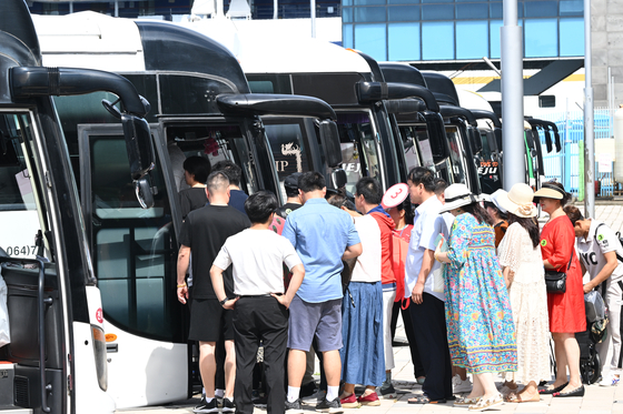 Chinese group tourists board rental buses to tour downtown Jeju on Aug. 31. [YONHAP]