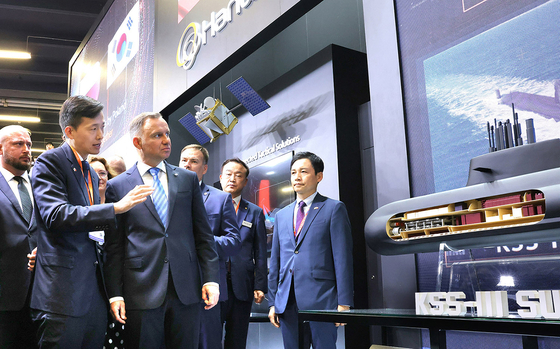 Hanwha Group Vice Chairman Kim Dong-kwan, center left, speaks with Polish President Andrzej Duda, right, at the International Defense Industry Exhibition (MSPO) 2023 held in Kielce, Poland, in front of a scale model of Hanwha Ocean's 3,000-ton KSS-III submarine on Tuesday. [HANWHA OCEAN]