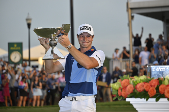 Viktor Hovland of Norway poses with the FedExCup Trophy after putting in to win on the 18th green during the final round of the Tour Championship at East Lake Golf Club in Atlanta, Georgia on Aug. 27. [GETTY IMAGES]