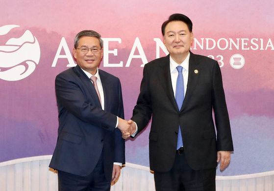 Korean President Yoon Suk Yeol, right, shakes hands with Chinese Premier Li Qiang ahead of a bilateral meeting at the Balai Sidang Jakarta Convention Center Thursday on the sidelines of the Asean gathering in Indonesia. [JOINT PRESS CORPS] 