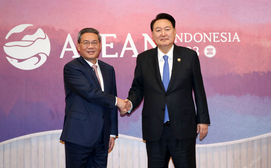Korean President Yoon Suk Yeol, right, shakes hands with Chinese Premier Li Qiang ahead of a bilateral meeting at the Balai Sidang Jakarta Convention Center Thursday on the sidelines of the Asean gathering in Indonesia. [JOINT PRESS CORPS]
