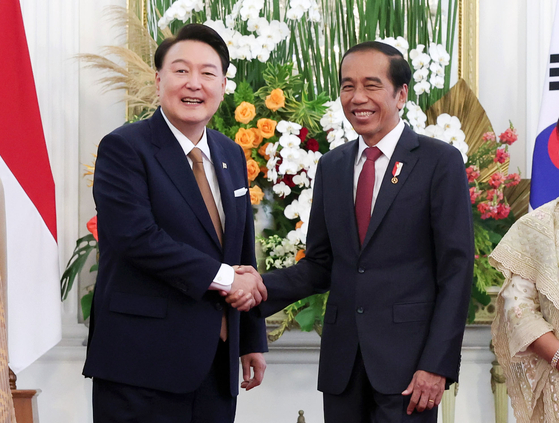 Korean President Yoon Suk Yeol, left, and Indonesian President Joko Widodo, right, shake hands at their bilateral summit at Merdeka Palace in Jakarta, Indonesia, Friday, on the margins of Asean-related meetings. [JOINT PRESS CORPS]