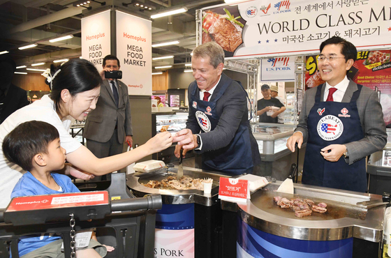 CEO of Homeplus Lee Jae-hoon, right, and Jim Pillen, governor of the U.S. state of Nebraska, grill and serve 1855 Black Angus beef from the United States at the Homeplus Mega Food Market in Gangseo District, western Seoul, on Thursday afternoon. Pillen's visit is in recognition of the hypermarket chain's handling of U.S. beef in large quantities and its exclusive retailing of 1855 Black Angus brand beef produced in Nebraska. [HOMEPLUS]