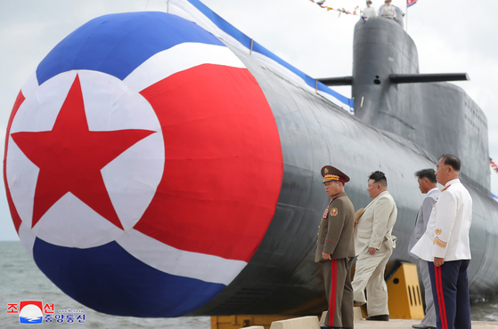 North Korean leader Kim Jong-un, second from left, attends a ceremony to launch a newly built ″tactical nuclear attack submarine” on Wednesday in a photo released by its official Korean Central News Agency on Friday. [YONHAP]
