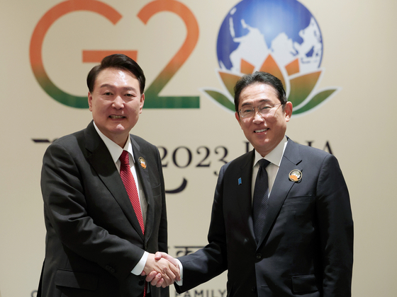 Korean President Yoon Suk Yeol, left, and Japanese Prime Minister Fumio Kishida shake hands ahead of a bilateral summit on the sidelines of the G20 summit in New Delhi Sunday. [JOINT PRESS CORPS]