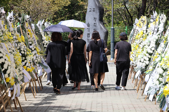 Flowers are lined up in front of a memorial for a teacher who died last Thursday after attempting suicide, at an elementary school in Daejeon on Saturday. The teacher, who was in her 40s, had been harassed by students’ parents and attempted suicide on Tuesday. According to the teachers’ union, the teacher had been harassed by the parents for four years, even after changing schools. The teacher is one of a handful of teachers who have resorted to suicide in the last two months, following the death of the Seo 2 Elementary School teacher in July. Sunday is World Suicide Prevention Day. [YONHAP]