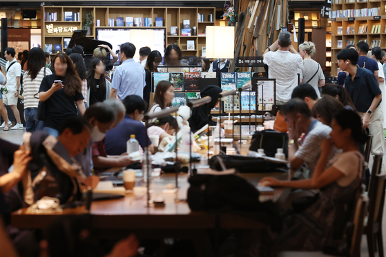 Citizens visiting COEX Mall in southern Seoul read books and look around the Byeolmadang library on July 23 . [YONHAP] 