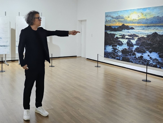 Lee Geon-su, the director of the Jeonnam International Sumuk Biennale, explains one of the art pieces on display at the annual art festival during a recent press event. [CHOI KYEONG-HO] 
