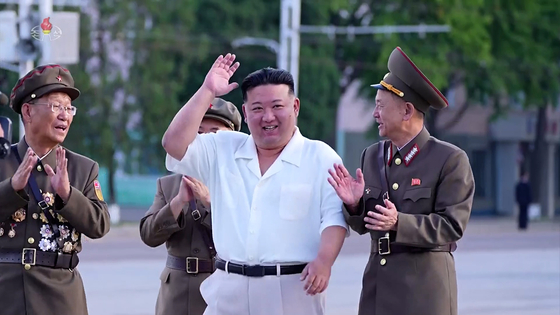 In this footage broadcast by Pyongyang’s state-controlled Korea Central Television, North Korean leader Kim Jong-un greets participants of Saturday’s paramilitary parade during a group photo session on Sunday. [YONHAP]