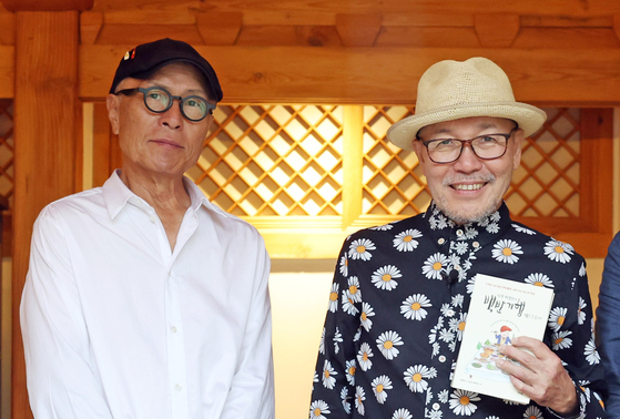Korean cartoonist Huh Young-man, left, and Japanese manga artist Masayuki Kusumi meet to discuss ways to revitalize bilateral cultural tourism exchanges through food, at a restaurant in Jongno District, central Seoul, on Wednesday. [MINISTRY OF CULTURE, SPORTS AND TOURISM]