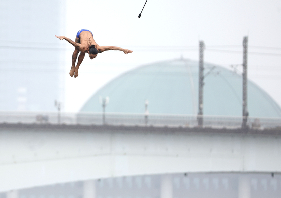 Korea's first professional high diver, Choi Byung-hwa, jumps off the Yanghwa Bridge in Seoul on Wednesday during the Red Bull Cliff Diving event. Along with Choi, British national Adian Heslop and Australian Xantheia Pennisi took the 18-meter (60-foot) plunge into the water. The Cliff Diving World Series has been held every year since 2009. This is the first time for it to be held in Korea. [YONHAP]
