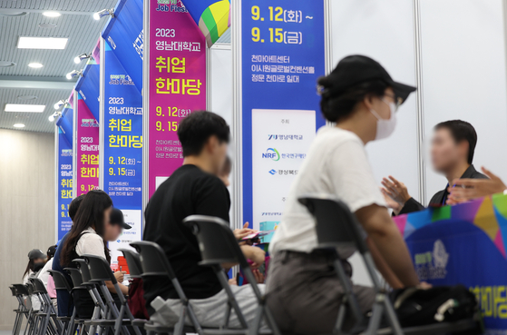 Job-seekers talk to company representatives at a career fair at Yeungnam University in Gyeongsan, North Gyeongsang, on Tuesday. [YONHAP]