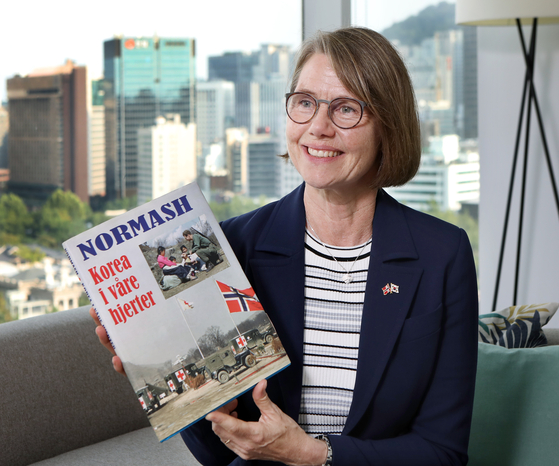 Anne Kari H. Ovind, ambassador of Norway to Korea, speaks with the Korea JoongAng Daily at the Norwegian Embassy in Seoul on Monday. She holds a book about Norwegian participation in the 1950-53 Korean War published by the Norwegian Korean War Veterans Association and the embassy. [PARK SANG-MOON]