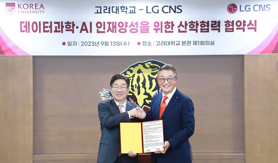 Korea University President Kim Dong-one, left, poses for a photo with LG CNS CEO Hyun Shin-gyoon after signing a memorandum of understanding on Wednesday. [LG CNS] 