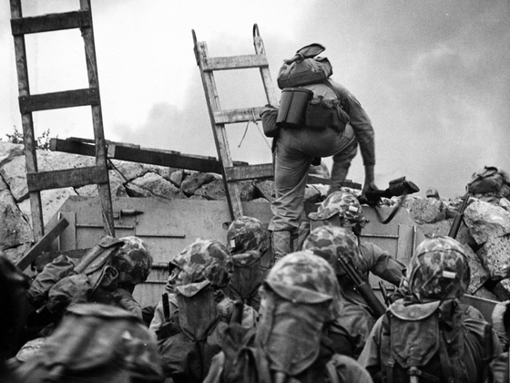 Lieutenant Baldomero Lopez of the Marine Corps scales a seawall after landing on Red Beach Point on Sept. 15, 1950. Lopez was killed covering a live grenade with his body minutes after the photo was taken. He was posthumously awarded the Medal of Honor. [U.S. NAVAL HISTORY AND HERITAGE COMMAND]