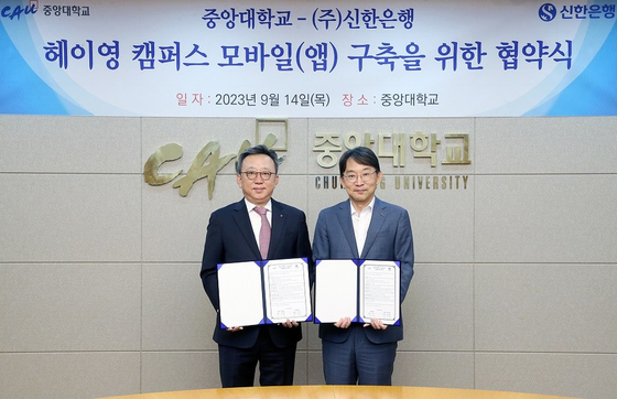 Shinhan Bank CEO Jung Sang-hyuk, left, pose for a photo with Chung-Ang University President Park Sang-gue at the university campus in Seoul on Thursday after signing a memorandum of understanding. [SHINHAN BANK]