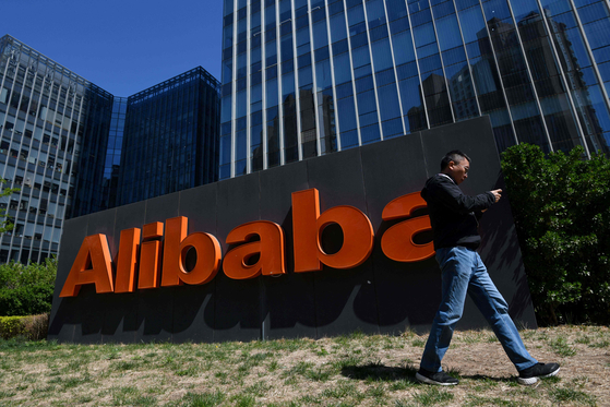 A man walks past an Alibaba sign outside the company's office in Beijing on April 13, 2021. [AFP]