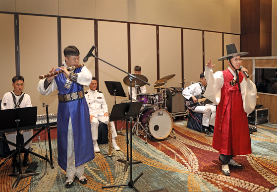 A traditional flutist and singer with the ROK Navy Band perform at the event. 