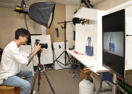 An employee at the Seoul Leather Manufacturing Support Center in Gandong District, eastern Seoul, takes a photo of a leather bag at the center's studio on Thursday. [PARK SANG-MOON]